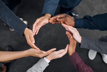 Poster - A representation of unity. Shot of a group of businesspeople with their hands joined together to form a circle.