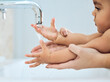 © Kay A/peopleimages.com - Raising a happy and healthy baby. Shot of a woman washing her babys hands under running water.