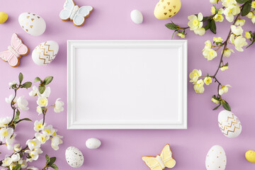 Wall Mural - Easter decor idea. Top view composition of white photo frame colorful easter eggs butterfly shaped cookies and cherry blossom branch on isolated violet background
