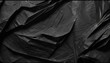 Abstract background of a sheet of black crumpled paper
