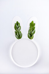 Wall Mural -  Bunny rabbit ears made of natural green leaves on white background with circle copy space. Flat lay. Easter minimal concept