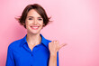 Photo of cheerful nice girl beaming smile indicate finger empty space isolated on pink color background