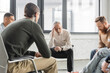 © LIGHTFIELD STUDIOS - Upset mature man with alcohol addiction sitting in circle during therapy in rehab center.