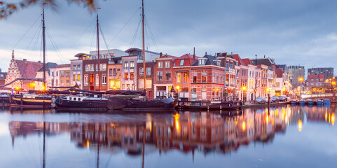 Wall Mural - Beautiful old houses on the city embankment of Leiden at sunset.