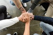 © LIGHTFIELD STUDIOS - Top view of multiethnic people holding hands together during anonymous alcoholics meeting in rehab center.
