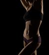© vladimirfloyd - Silhouette of a slim woman's body over dark background
