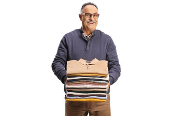 Poster - Cheerful mature man holding a pile of folded clothes and smiling at camera