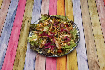 Wall Mural - Appealing crispy breaded fried chicken salad with lettuce, cherry tomatoes, red onion and sweet corn