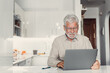 © Daniel - Aged remote worker. Concentrated senior male in glasses work on laptop from home office read email electronic document. Old age man employee freelancer sit at kitchen table by pc typing report online.