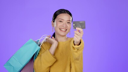 Wall Mural - Shopping bag, credit card and smile with asian woman in studio for deal, discount and sales. Finance, promotion and payment with girl customer for wealth, product and offer on purple background