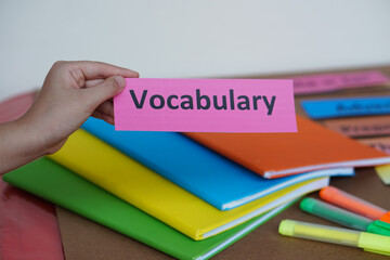 closeup student's hand hold english vocabulary word card. concept, education, learning, studying lan