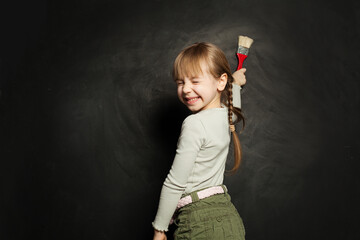 Wall Mural - Happy child girl painting on school blackboard. Back to school, education, student, pupil