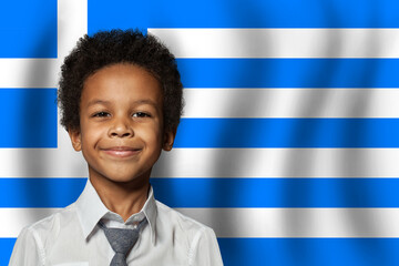 Wall Mural - Greek kid boy on flag of Greece background. Education and childhood concept