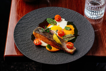 Wall Mural - grilled salmon steak with sauce in a plate on a wooden table