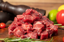 Raw Fresh Beef Or Lamb Cubes. Diced Red Beef Meat On A Wood Serving Board. Raw Casserole Or Stewing Beef Diced. Close Up