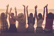 © simona - Group of women outdoor enjoying freedom and happiness raised arms against a golden sunset at the beach in holiday vacation travel lifestyle. Friendship girls together. Joyful people and nature outside