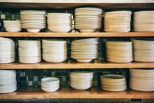 Close-up Of Plates And Bowls On Shelves At Commercial Kitchen