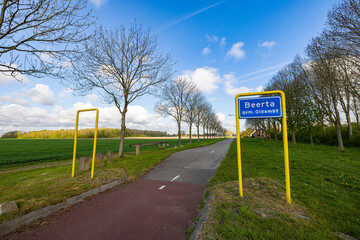 Wall Mural - street view in the northern part of the Netherlands of a road with sign of village