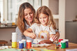 © A.S./peopleimages.com - Mother, girl and painting art in house studio, home or creative space with brush, oil paint or palette. Happy smile mom, child or kid bonding in relax design or class activity for adhd or autism help