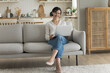 © fizkes - Happy attractive mature freelancer woman working at laptop at home, holding computer on lap, sitting on couch, talking on video call, looking at screen, laughing, enjoying Internet communication