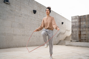 Wall Mural - one woman young adult caucasian female with jumping rope training