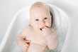 Cute baby girl taking a bath. Child health care.