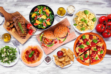 Poster - Table scene with an assortment of delicious foods. Top view over a white wood background.