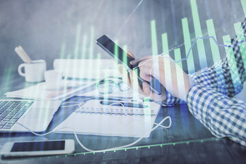 Poster - Double exposure of man's hands holding and using a digital device and forex graph drawing. Financial market concept.
