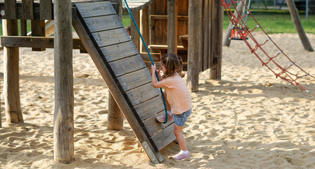 Beautiful baby  having fun on sunny warm summer day - Cute toddler girl playing in sand on outdoor playground