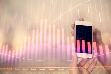 Wall Mural - Double exposure of forex chart sketch hologram and woman holding and using a mobile device. Stock market concept.