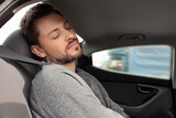 Fototapeta  - Tired handsome man sleeping in his modern car