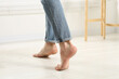 © New Africa - Barefoot man walking on white parquet indoors, closeup. Heated floor