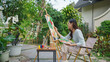 Creative art concept, Female artist painting on canvas with brush and watercolor in outdoor garden