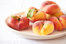 Close-up Of Peaches In Plate Over White Background