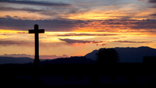 Silhouette Cross Against Cloudy Sky During Sunset