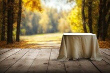 Empty Wooden Table With Tablecloth Over Autumn Nature Park Background