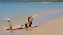 Girl Lies On The Beach With Sea Waves	