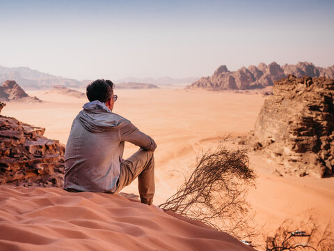 stylish man and the sights of the wadi rum desert in jordan. clear, sunny day. vacation and travel c