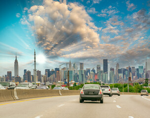 Poster - Major road to New York City at sunset. Car traffic at dusk