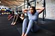 © Flamingo Images - Focused woman doing sit-ups in a gym class