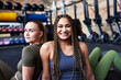 © Flamingo Images - Smiling young women sitting back to back at the gym