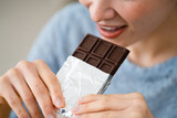 チョコレートを食べる若い女性　飲食イメージ