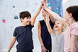 © Flamingo Images - Little kids high fiving in a bouldering gym