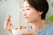 ミックスナッツを食べる若い女性　飲食イメージ