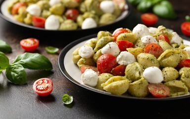 Wall Mural - Pesto Pasta Salad with Cherry Tomatoes and Mozzarella cheese. Healthy food.
