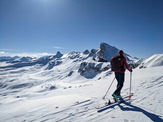 a woman on a ski tour towards erdisgulmen in the flumserberg. ski climbing in beautiful switzerland.