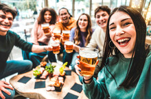 Girl Taking A Selfie While Toasting Beers -  Friends Clinking Ale At Brewery Bar Indoor At Patio Party - Friendship Concept With Young People Having Fun Together Drinking At Happy Hour Promotion .