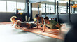 © Flamingo Images - People doing push-ups in a gym