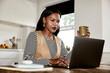 © Flamingo Images - Businesswoman drinking coffee and using a laptop