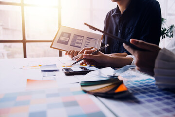Close up ux developer and ui designer brainstorming about mobile app interface wireframe design on table with customer breif and color code at modern office.Creative digital development agency